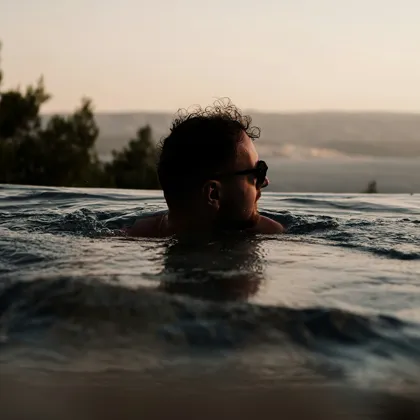 Man swimming at sunset