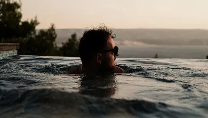 Man swimming at sunset