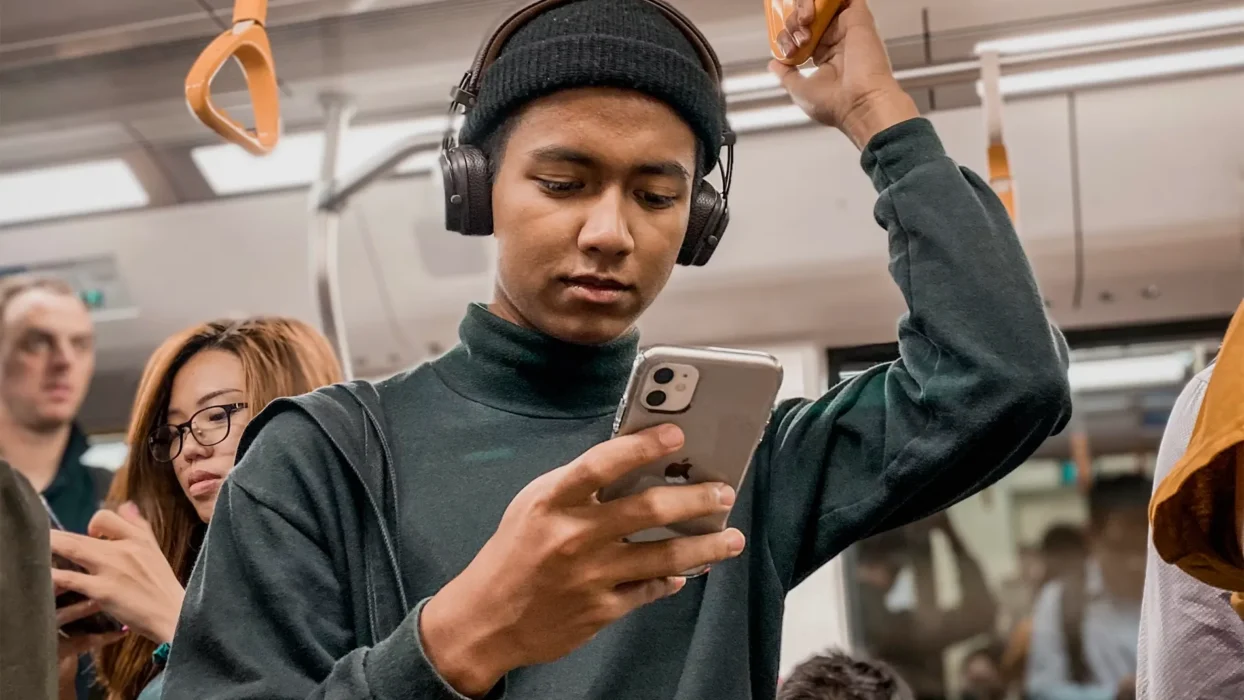 man on train holding smartphone