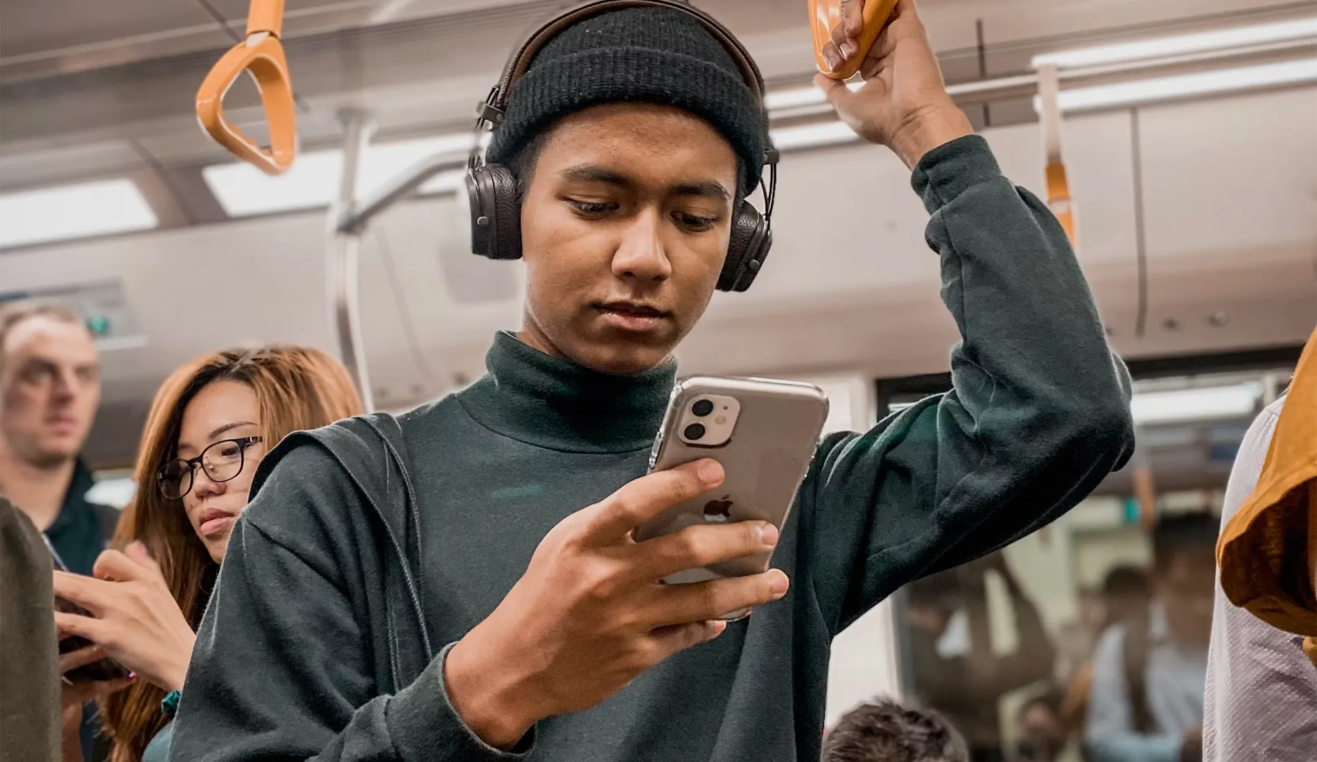 man on train holding smartphone